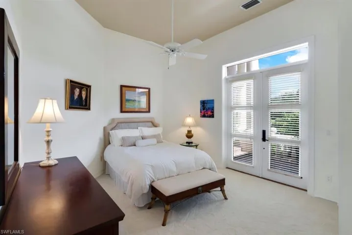 Carpeted bedroom featuring french doors, access to exterior, and ceiling fan