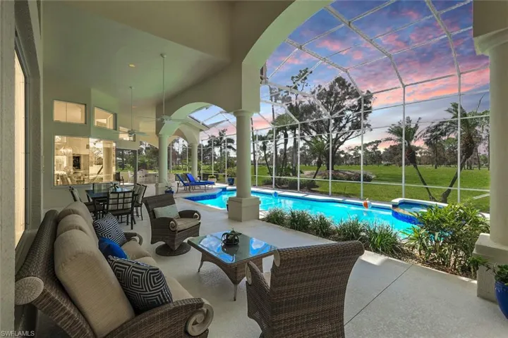 Pool at dusk with a lanai, ceiling fan, an outdoor living space, and a patio