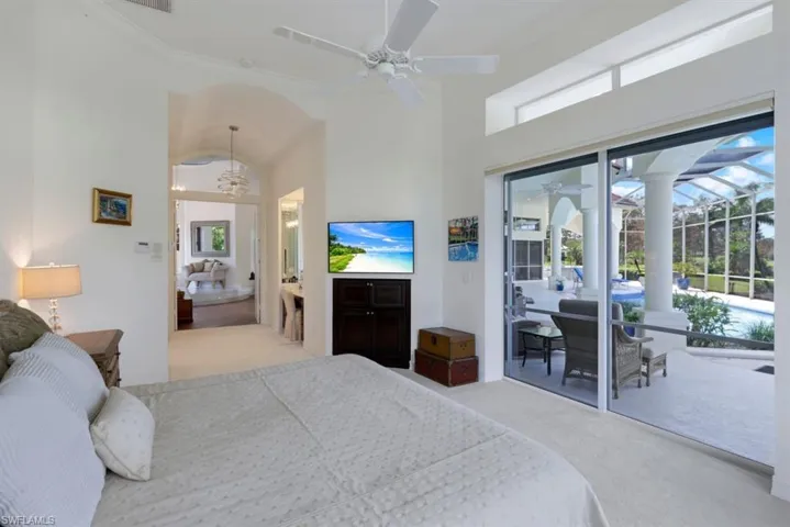 Bedroom featuring light carpet, ceiling fan, access to outside, high vaulted ceiling, and ornamental molding