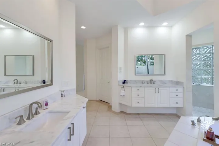 Bathroom with vanity, a healthy amount of sunlight, and tile patterned floors
