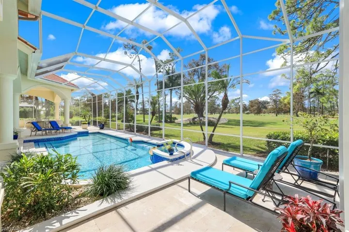 View of swimming pool with a patio area, glass enclosure, and a lawn