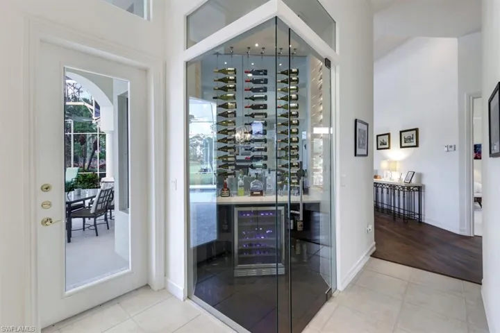 Wine room featuring wine cooler, bar, and light hardwood / wood-style flooring