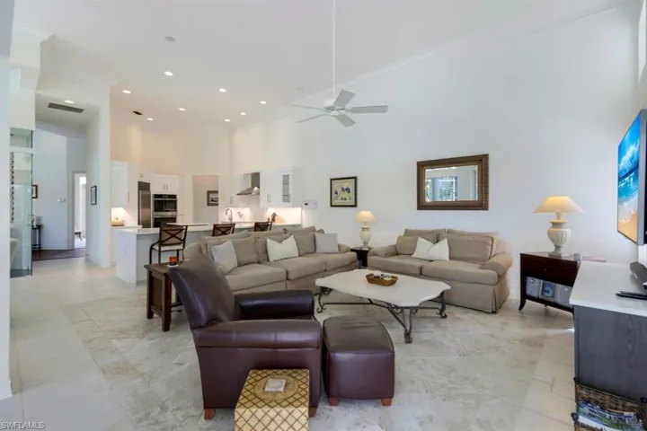 Living room featuring ceiling fan and a high ceiling