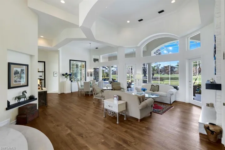 Living room featuring a towering ceiling, dark hardwood / wood-style floors, and ornamental molding