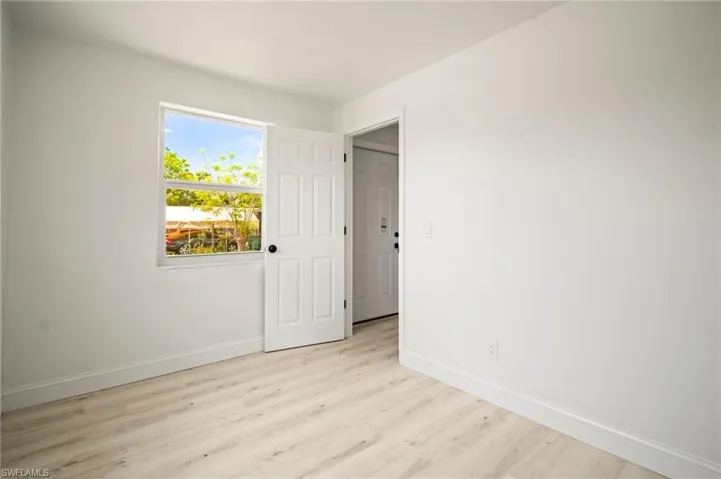 Unfurnished bedroom with baseboards and light wood finished floors