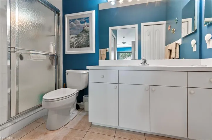 Bathroom with tile patterned flooring, vanity, toilet, and walk in shower