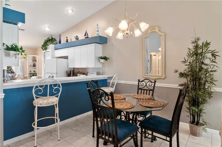 Tiled dining area featuring an inviting chandelier