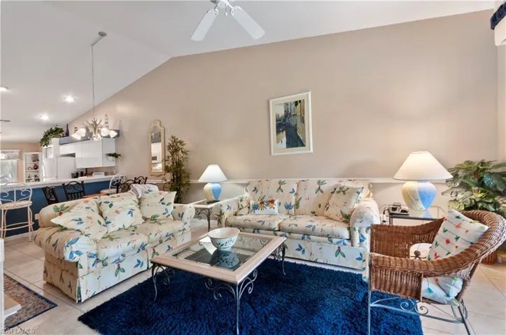 Tiled living room featuring ceiling fan and lofted ceiling