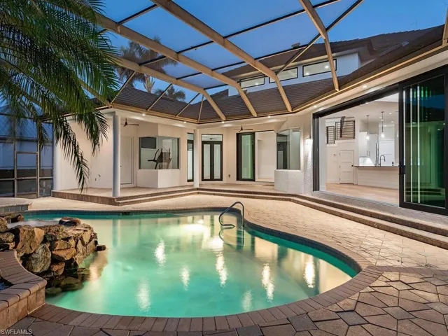 View of swimming pool with spacious pool deck, heated pool, and spa