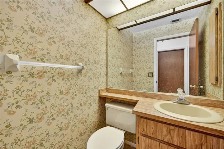 Half bathroom featuring vanity and toilet