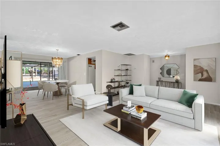 Virtually Staged Living room with a chandelier and light wood finished floors