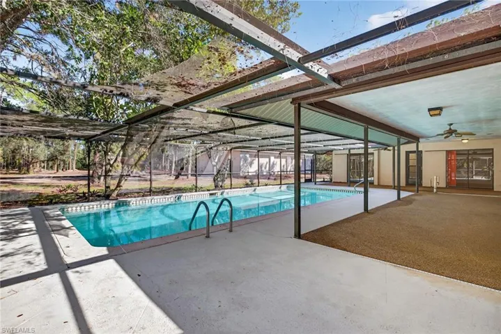 Swimming pool featuring glass enclosure and a patio