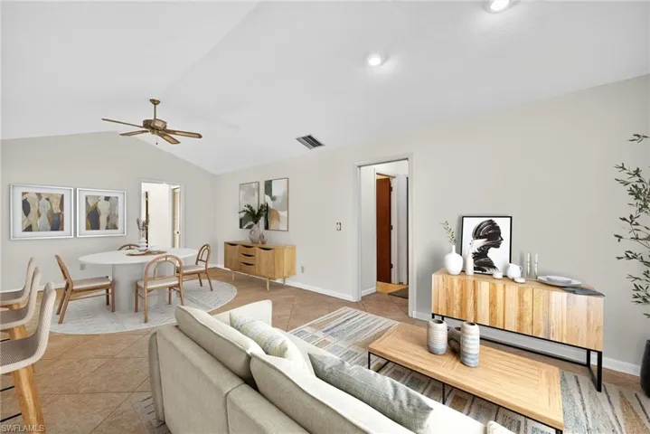 Virtually Staged Living room featuring light tile patterned flooring, a ceiling fan, and lofted ceiling