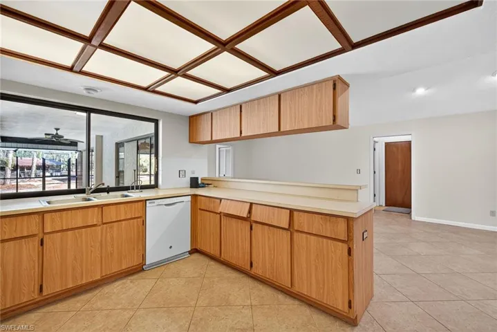 Kitchen featuring a peninsula, light countertops, white dishwasher, and open floor plan
