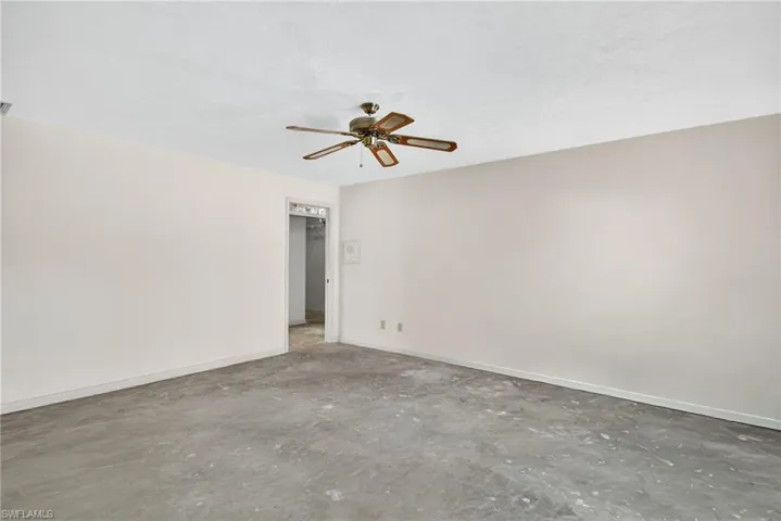 Spare room featuring unfinished concrete flooring and a ceiling fan