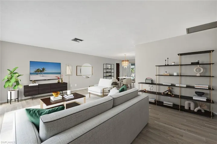 Virtually Staged Living room featuring a chandelier and wood finished floors