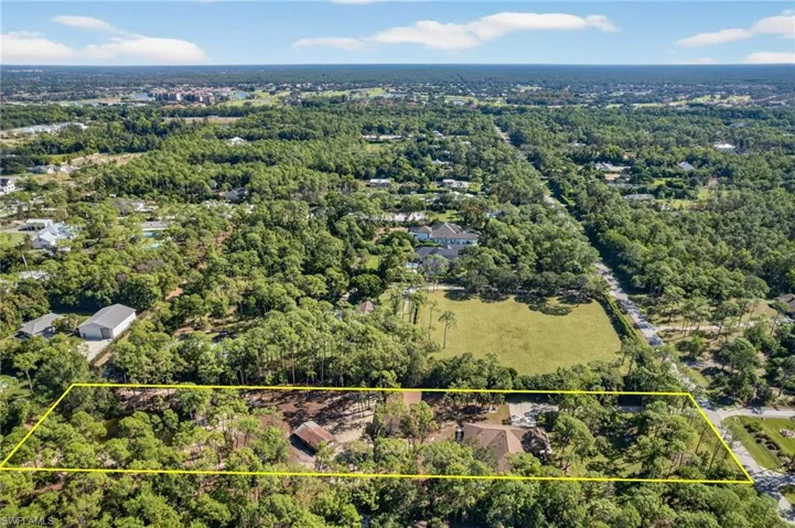 Aerial view of property's location with property boundaries highlighted and a heavily wooded area