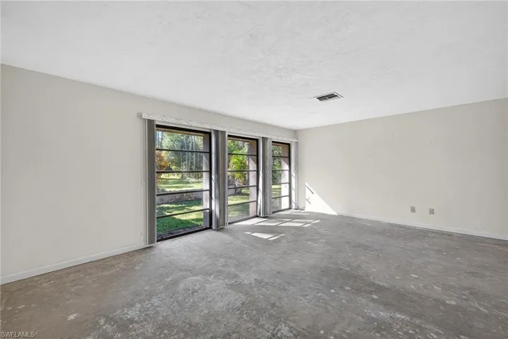 Spare room with unfinished concrete flooring and a textured ceiling