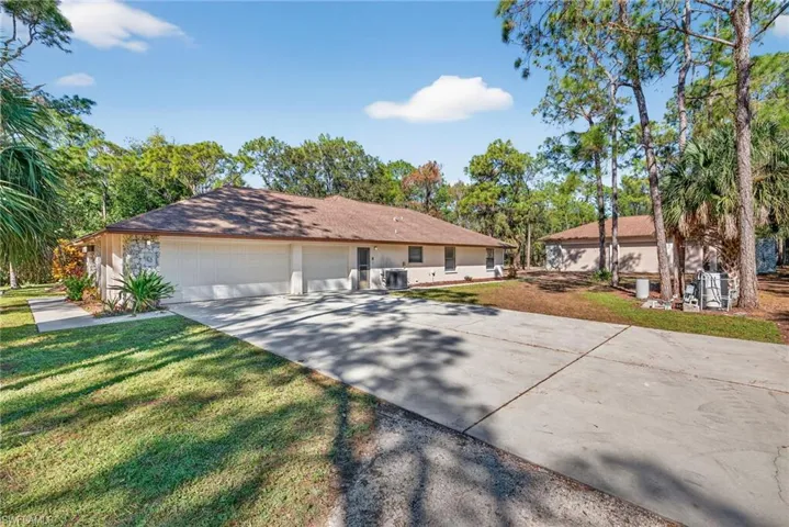 Ranch-style home with driveway, a front yard, and an attached garage
