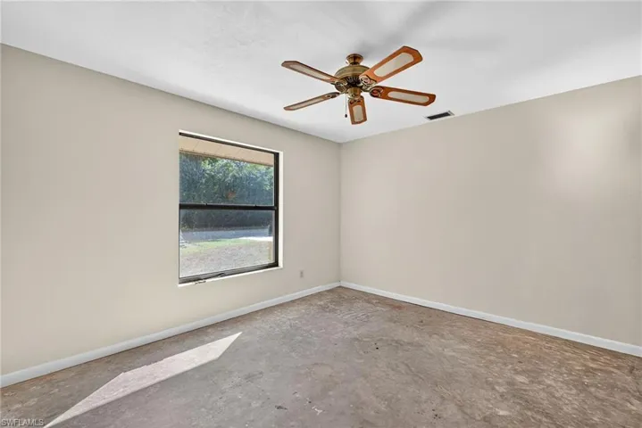 Unfurnished room featuring ceiling fan and unfinished concrete floors