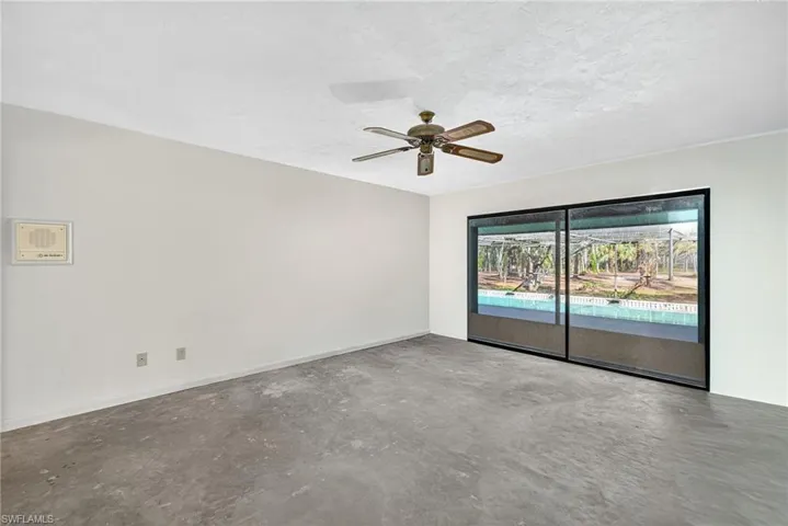 Unfurnished room with unfinished concrete floors, a ceiling fan, and a textured ceiling