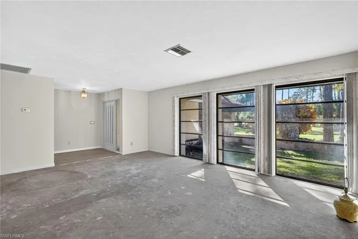 Empty room featuring baseboards and unfinished concrete flooring