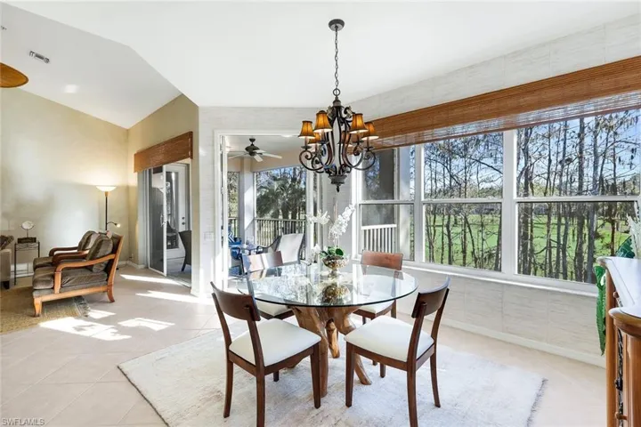 Tiled dining space featuring a chandelier and baseboards