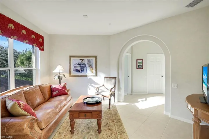 Living room with arched walkways and tile patterned flooring