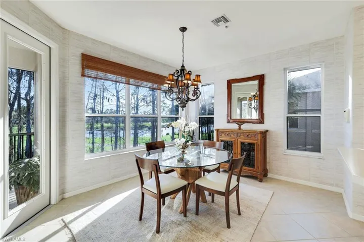 Dining room featuring suspended lighting, tile patterned flooring, and tile walls