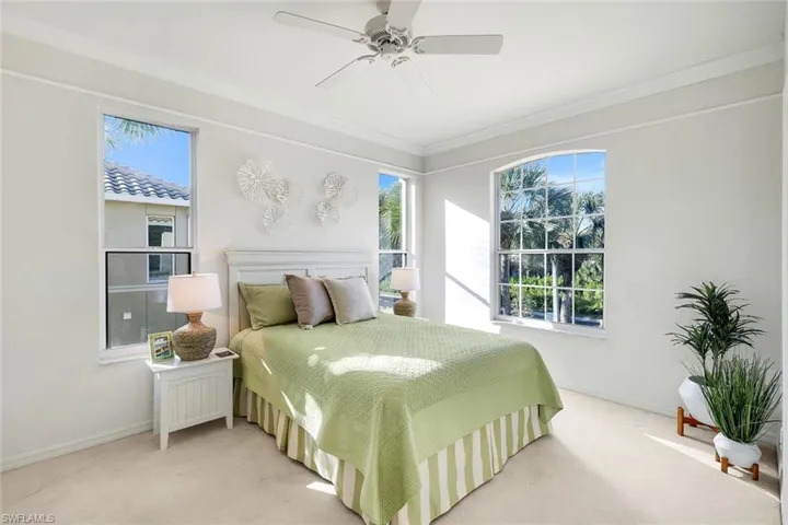 Carpeted bedroom featuring ornamental molding and ceiling fan