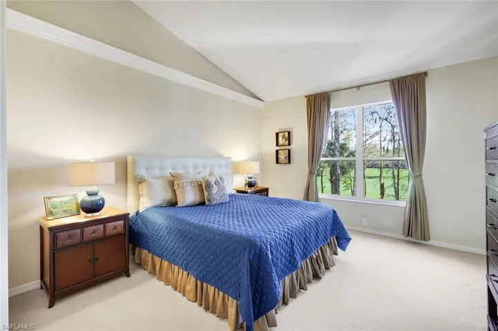 Bedroom with vaulted ceiling and carpet