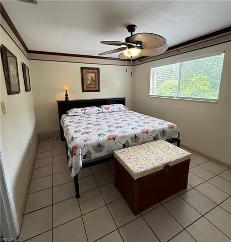 Room featuring tile flooring, a window with horizontal blinds, and a ceiling fan with integrated lighting