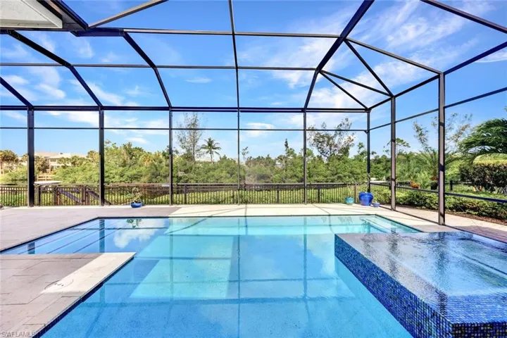 View of swimming pool with a patio and glass enclosure