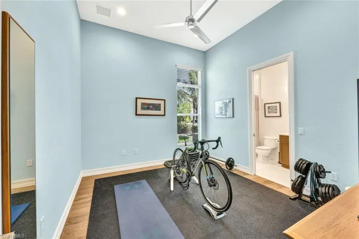 Workout room with hardwood / wood-style flooring and ceiling fan
