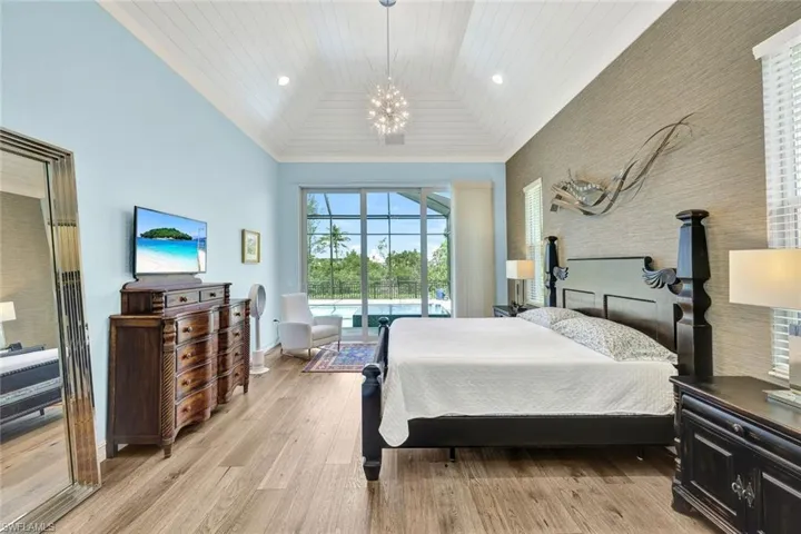 Bedroom with high vaulted ceiling, a chandelier, wooden ceiling, and light wood-type flooring