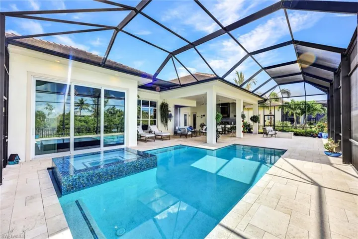 View of swimming pool with an in ground hot tub, a patio area, and a lanai