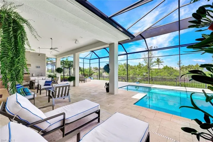 View of swimming pool featuring an outdoor hangout area, a patio, glass enclosure, and ceiling fan