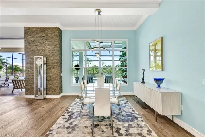 Dining room featuring beam ceiling, crown molding, and wood flooring