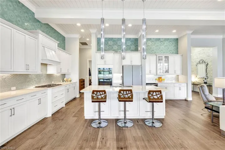 Kitchen featuring light hardwood / wood-style flooring, wood cabinets, a kitchen island with sink, and stainless steel appliances and natural gas stovetop