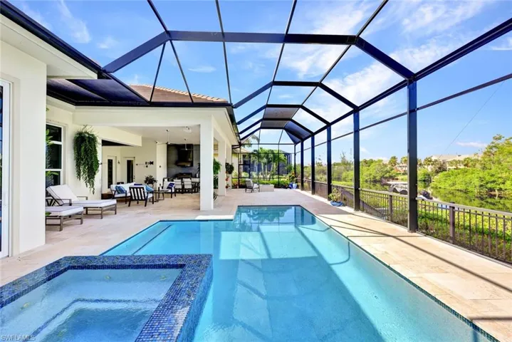 View of pool with an in ground hot tub, screened lanai,  enclosure, and outdoor lounge area