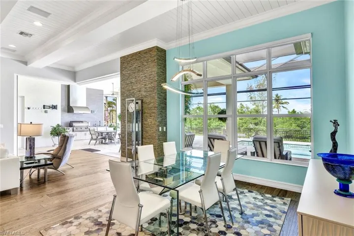 Dining space featuring beamed ceiling, ornamental molding, hardwood / wood-style flooring, and wooden ceiling
