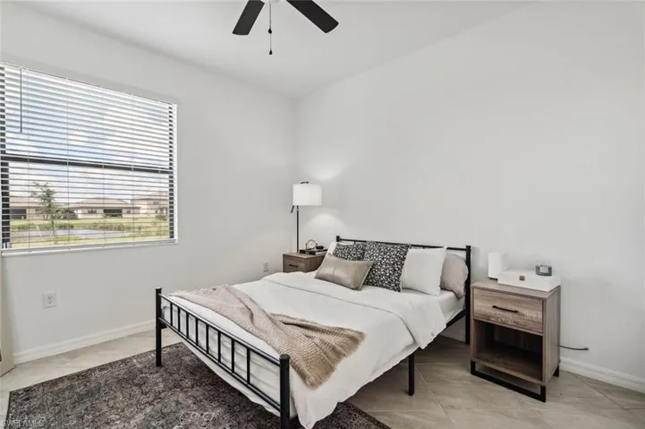 Bedroom with a ceiling fan and light tile patterned floors
