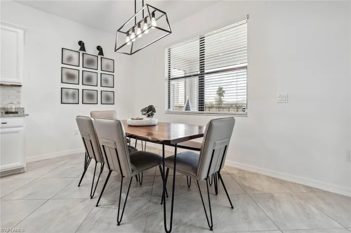 Dining space with light tile patterned floors and baseboards
