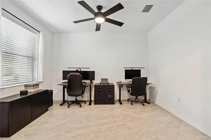 Office area featuring a ceiling fan and baseboards