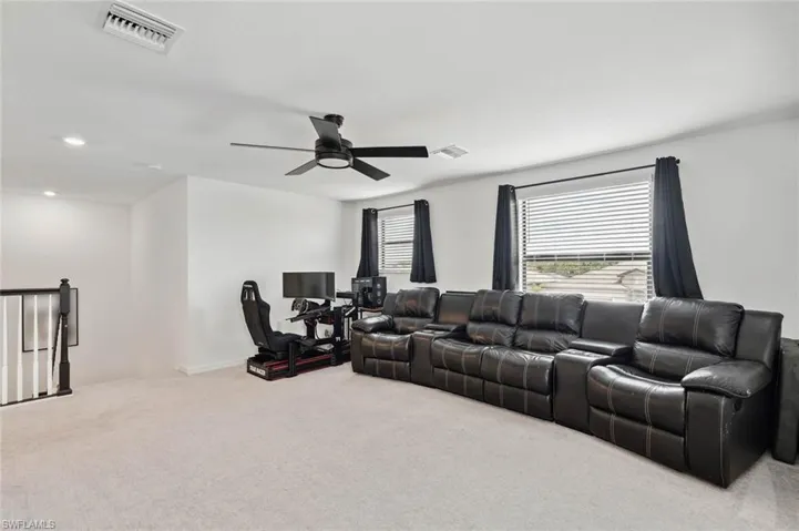 Living room with light carpet and a ceiling fan