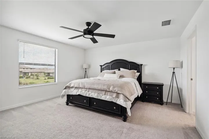 Bedroom with light carpet and ceiling fan