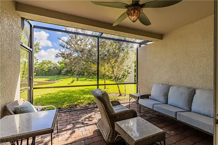 Screened in covered patio with ceiling fan and private water views