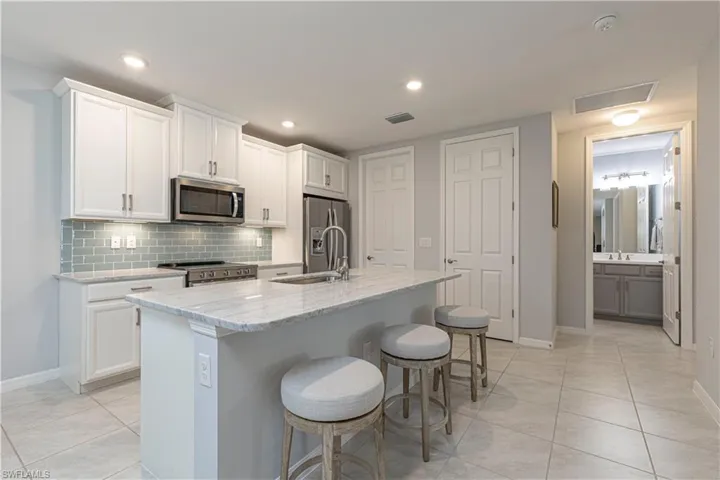Kitchen featuring white cabinets, a center island, and stainless steel appliances
