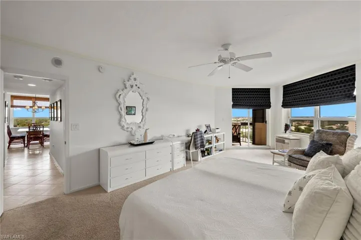 Bedroom with multiple windows, access to exterior, ornamental molding, light colored carpet, and a ceiling fan