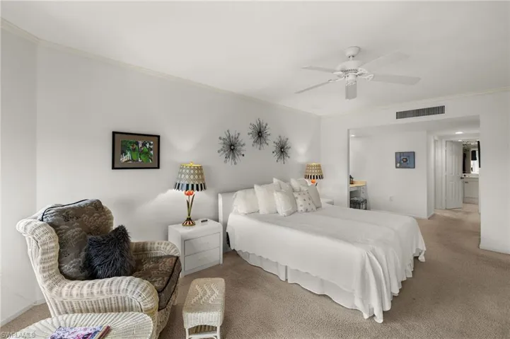 Carpeted bedroom with ornamental molding and a ceiling fan